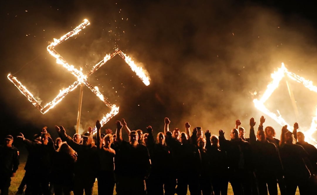 Members of the National Socialist Movement, one of the largest neo-Nazi groups in the US, hold a swastika burning after a rally on April 21, 2018 in Draketown, Georgia - Photo: Spencer Platt/AFP