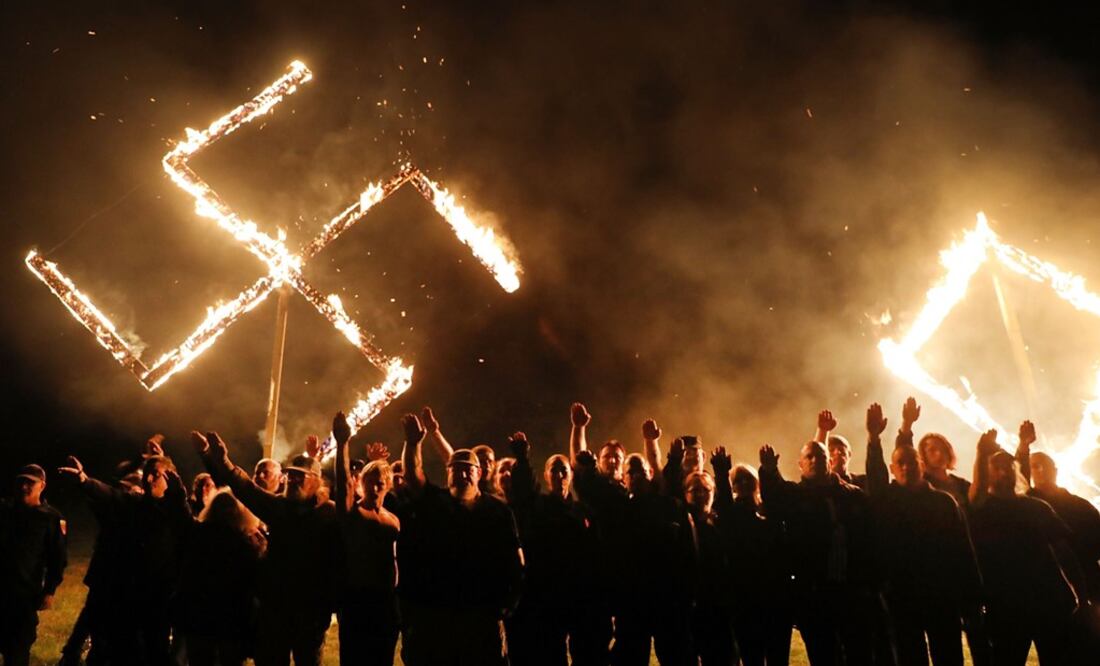 Members of the National Socialist Movement, one of the largest neo-Nazi groups in the US, hold a swastika burning after a rally on April 21, 2018 in Draketown, Georgia - Photo: Spencer Platt/AFP