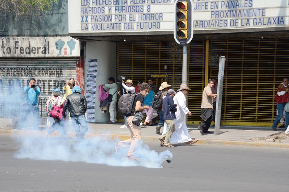 Oficiales de la Policía Federal lanzaron granadas de gas a los manifestantes sobre avenida Bucareli esquina con Ayuntamiento, donde estaba instalada una valla metálica para evitar el paso rumbo a la Secretaría de Gobernación. (MARIO JASSO. CUARTOSCURO)