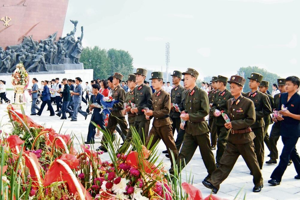 Personal de servicio y civiles llevan en Pyongyang flores a las estatuas de sus líderes, ayer, en el 68 aniversario de que Kim Il-Sung fundara la República Popular Democrática de Corea (RPDC) (REUTERS)