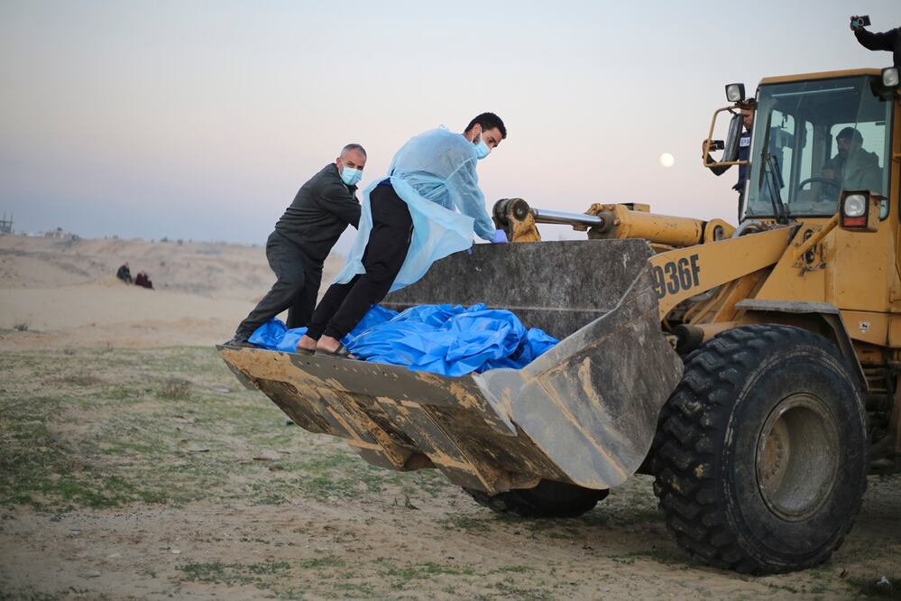 Bulldozer transporta los cuerpos de palestinos asesinados en el norte de la Franja de Gaza y entregados por el ejército israelí durante un funeral masivo en Rafah. Foto: AP