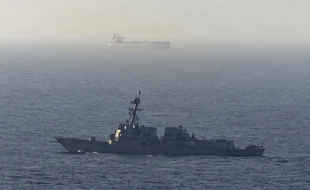 Fotografía tomada de la cuenta en X @CENTCOM del Comando Central de Estados Unidos de un destructor de misiles guiados estadounidense cerca de un buque de carga en el mar Arábigo. El Ejército de EU negó que buques comerciales hayan burlado su bloqueo de los puertos iraníes en el estrecho de Ormuz. Foto: EFE
