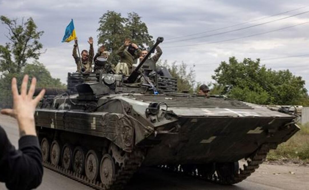 Residente local saluda a los soldados de Ucrania que viajan en un vehículo blindado en Mala Komyshuvakha, cerca de Izyum, región de Kharkiv. Foto: AFP