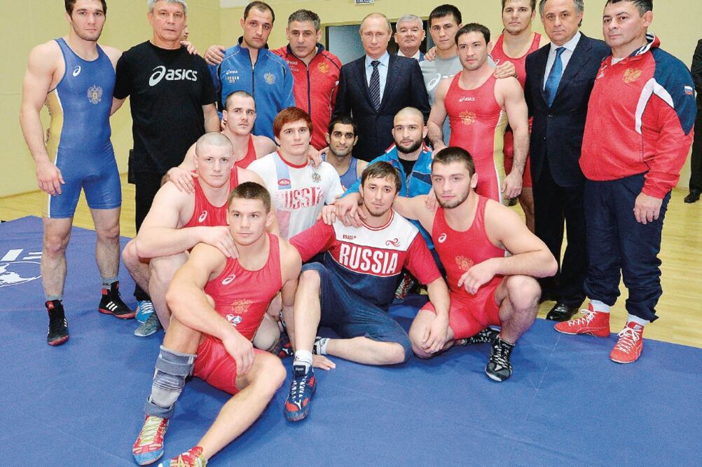 Vladimir Putin y el ministro del deporte, Vitaly Mutko, posan con atletas (ALEXEI DRUZHININ. AP)