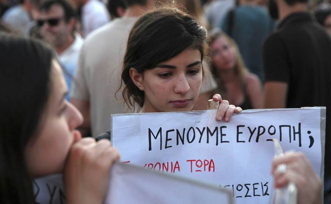 Cientos se manifestaron en Atenas contra la austeridad. En la foto, una joven sostiene una pancarta que dice: ¿Nos quedamos en el euro?  Foto: Reuters