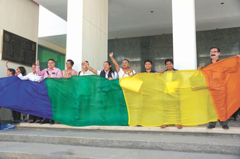 Tras más de cinco de horas de sesión, una bandera multicolor fue ondeada por la comunidad LGBTTTIQ en las escalinatas, frente al recinto legislativo de San Raymundo Jalpan, como señal de júbilo. Foto: EDWIN HERNÁNDEZ. EL UNIVERSAL