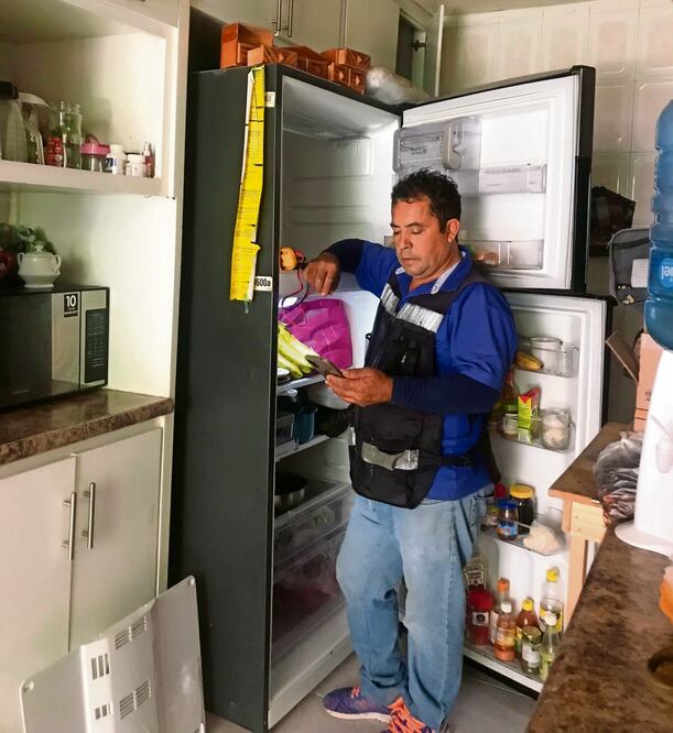 David González le da prioridad a la reparación de los refrigeradores descompuestos en hogares de familias. Foto: Xóchitl Álvarez / EL UNIVERSAL