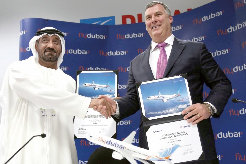 Sheikh Ahmed bin Saeed al-Maktoum, presidente de Flydubai y Emirates, da un apretón de manos a Kevin McAllister, presidente y director de Boeing Commercial Airplanes tras cerrar un trato en el Dubai Airshow, en Dubai. Foto: SATISH KUMAR. REUTERS