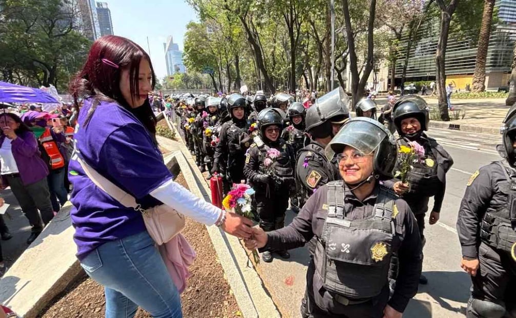 Mujeres policías de la SSC CDMX reciben flores durante la marcha del domingo 8 de marzo de 2026. Foto: Especial