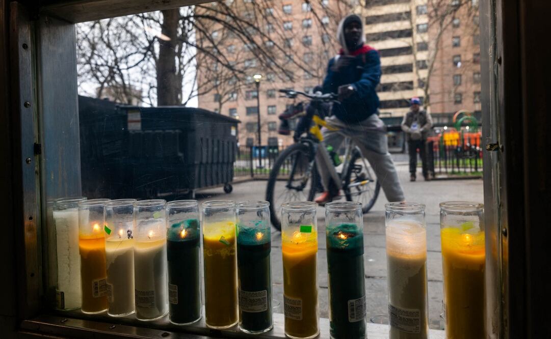 Velas frente al lugar donde una bebé de siete meses murió por una bala perdida en Brooklyn, Nueva York. Foto: AFP.
