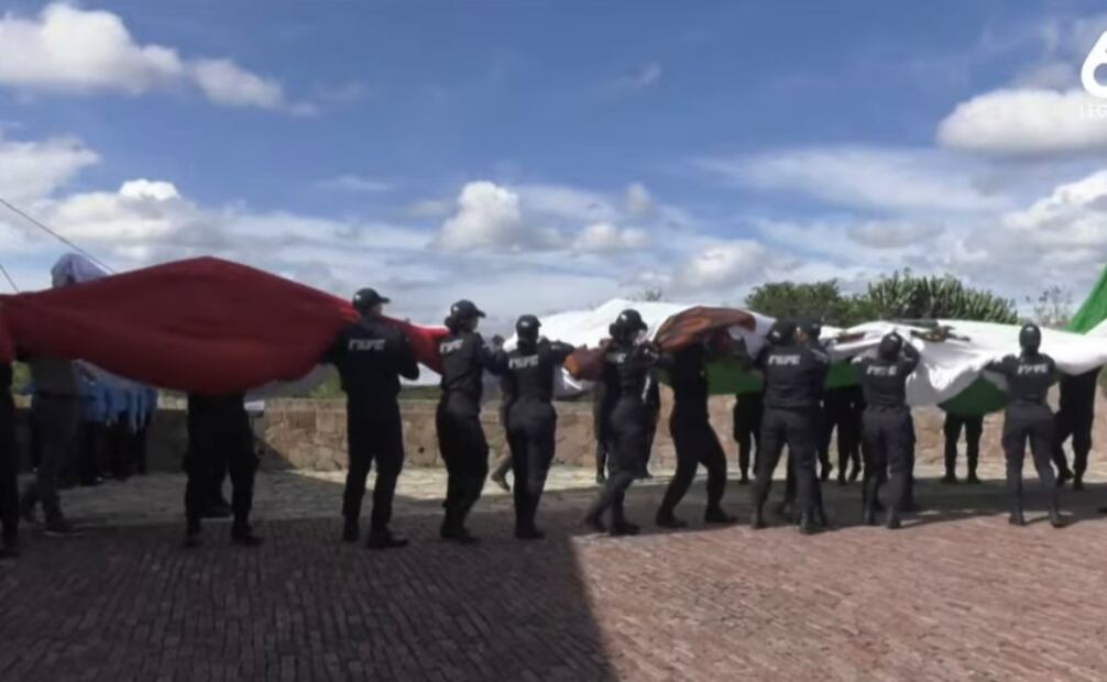 Elementos de seguridad evitaron que la bandera cayera al suelo (15/09/2025). Foto: Especial