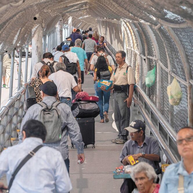 Migrantes cruzan el Puente Internacional Paso del Norte, en Ciudad Juárez, Chihuahua, rumbo a Estados Unidos. PAUL RATJE. AFP