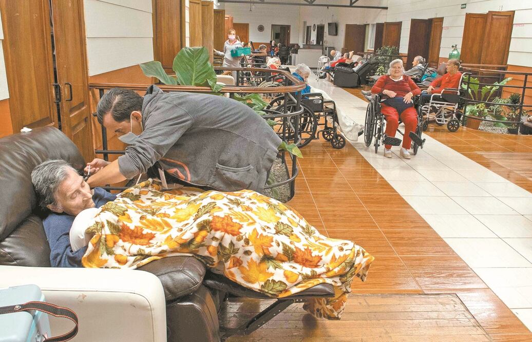 Un empleado sanitario vacuna contra el coronavirus a una mujer en la Casa Israel Residencia Geriatrica, en Cartago, Costa Rica. Especialistas lamentan que a diferencia de la Unión Europea, en América Latina "cada uno va por su lado". Foto: AFP