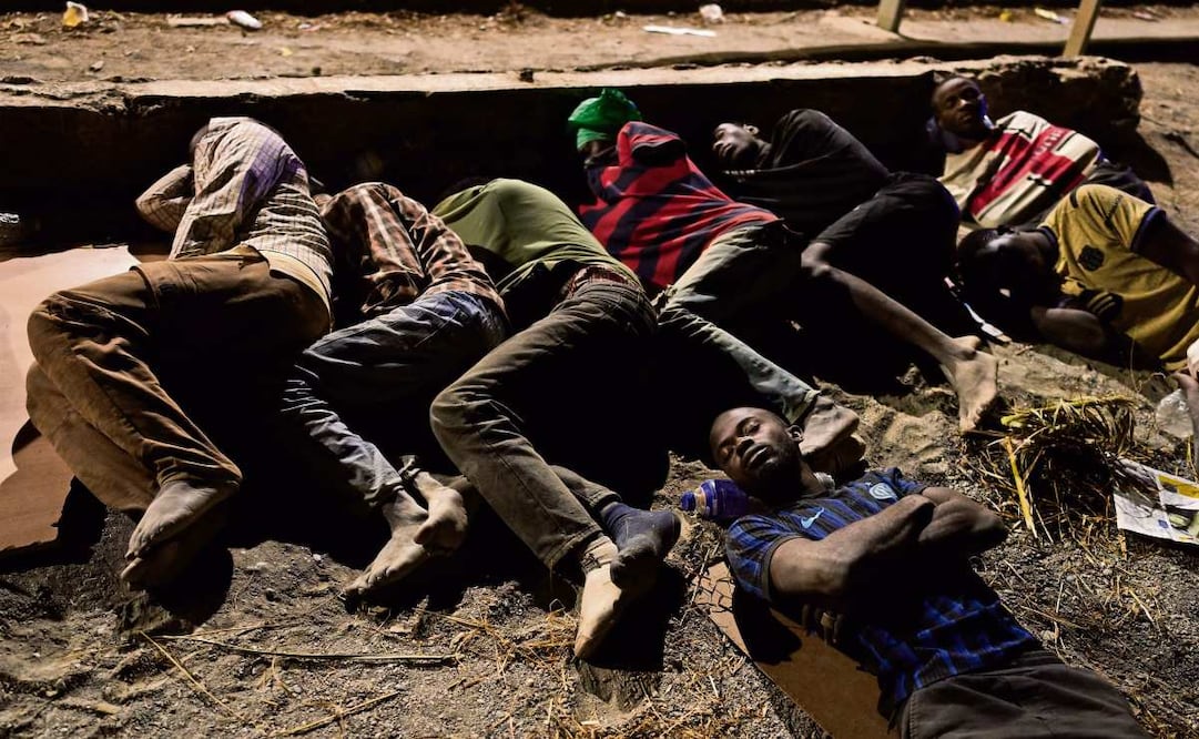 Migrantes que cruzaron hacia España desde Marruecos duermen en la playa en Ceuta. Foto: AP /Bernat Armangue