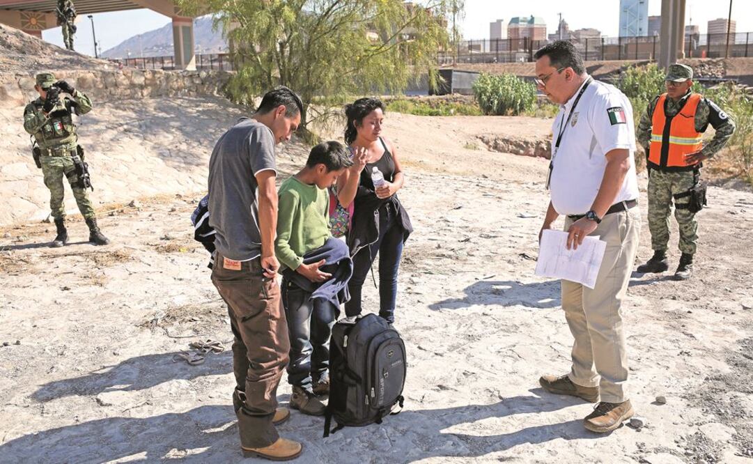 Oficiales del Instituto Nacional de Migración hablan con hondureños tras ser detenidos por elementos de la Guardia Nacional, en Ciudad Juárez. JOSÉ LUIS GONZÁLEZ. REUTERS