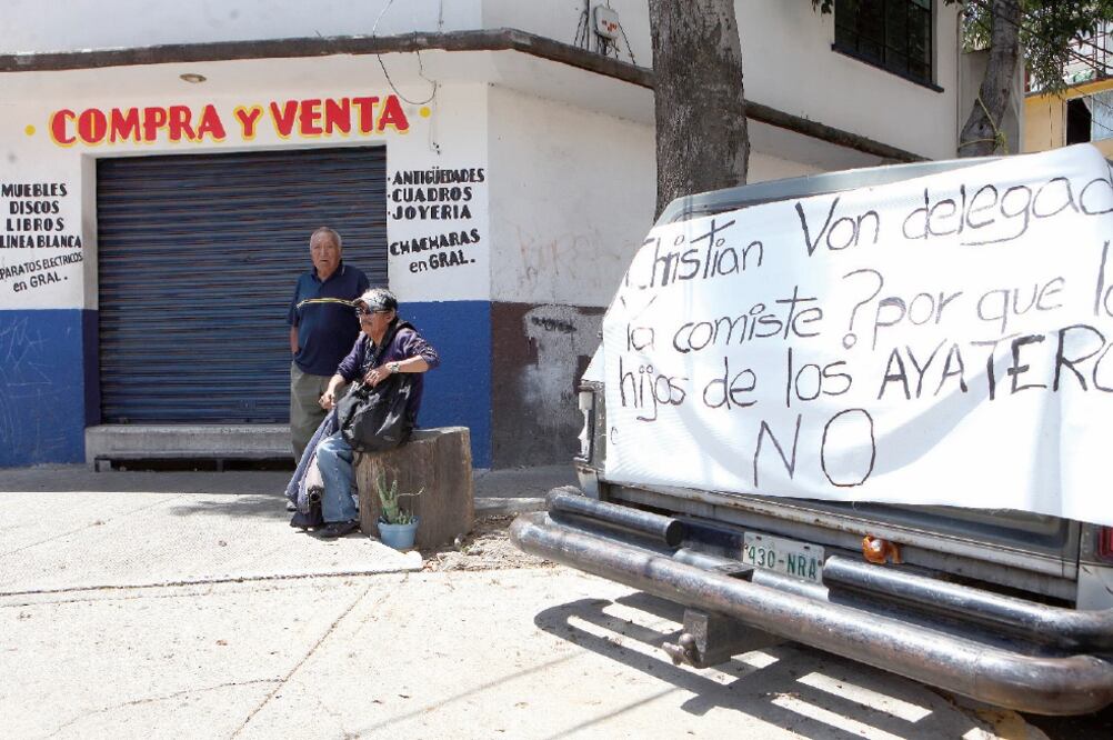 Un grupo de ayateros se mantiene al cuidado de las bodegas donde resguardan su mercancía, mientras al menos tres camionetas de las autoridades así como policías a pie resguardan la zona (VALENTE ROSAS. EL UNIVERSAL)