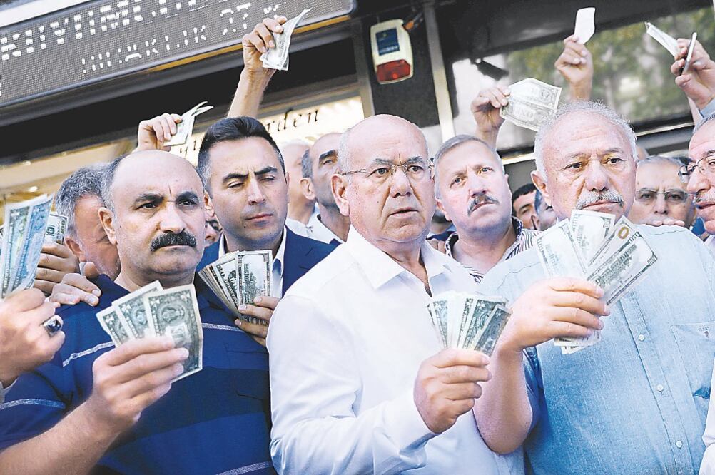 Empresarios acudieron ayer en Ankara a las casas de cambio para vender sus dólares y euros y respaldar así la moneda turca, la lira. (UMIT BEKTAS. REUTERS)