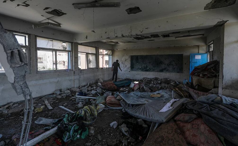 Un palestino inspecciona los daños en un edificio escolar de la UNRWA destruido tras un ataque aéreo israelí en el campo de refugiados de Al Nusairat. Foto: EFE