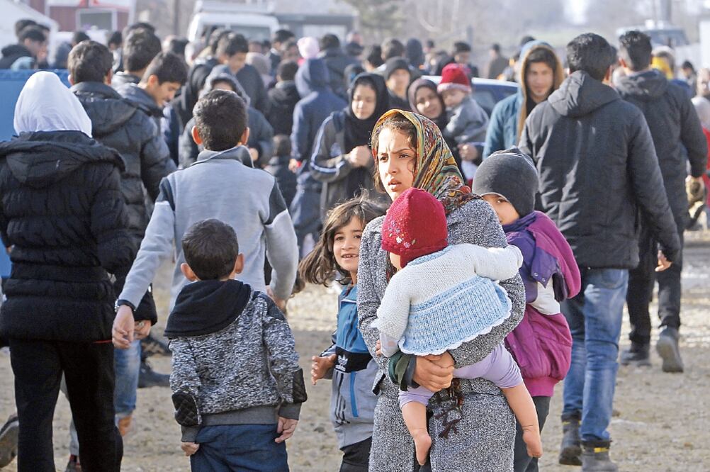 Refugiados y migrantes, en su mayoría de Afganistán, recorren el centro de tránsito para refugiados cerca de la localidad macedonia de Tabanovce, a la espera de poder cruzar la frontera hacia Serbia (BORIS GRDANOSKI. AP)