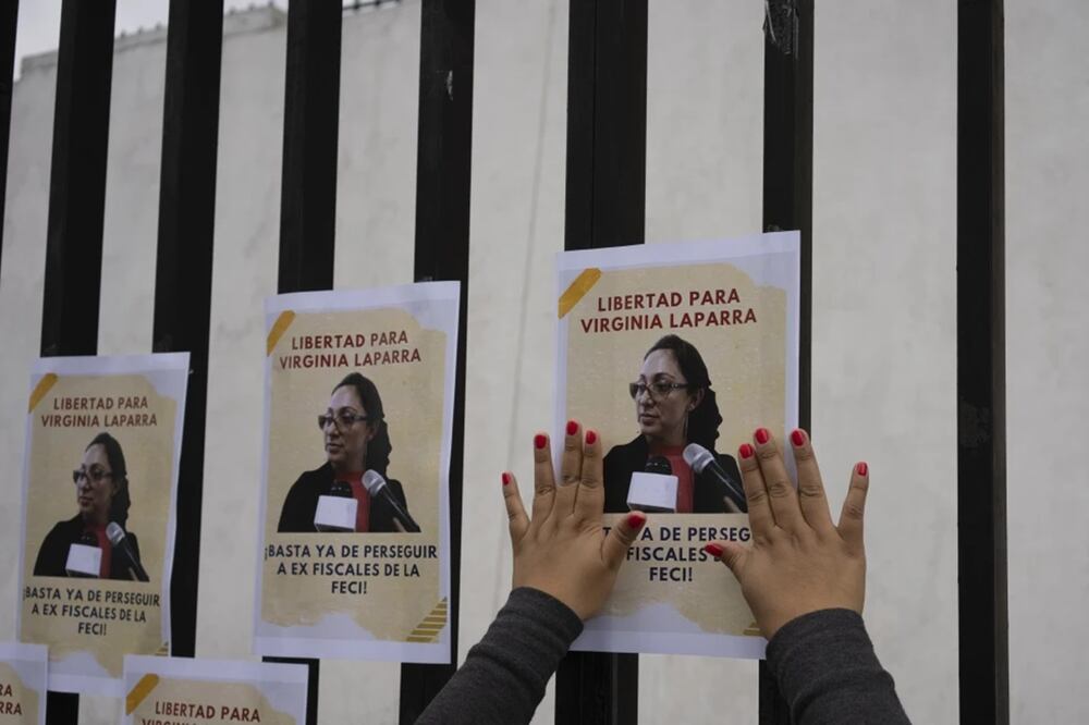 Una mujer coloca panfletos de apoyo a la fiscal guatemalteca Virginia Laparra, en Ciudad de Guatemala el 7 de junio de 2022. Foto: AP