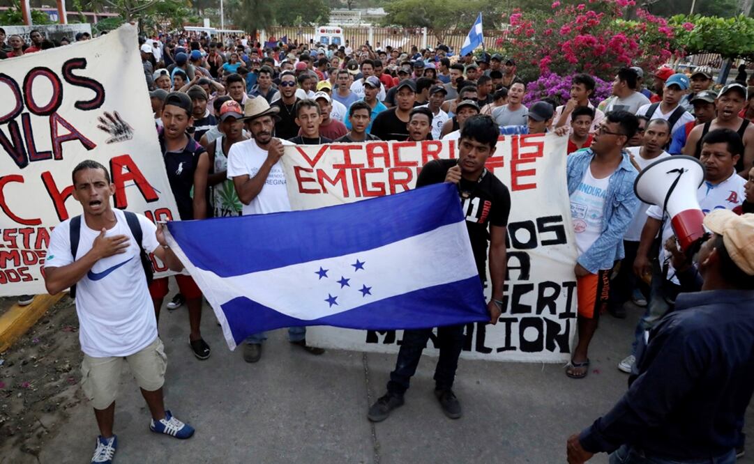 Members of the migrant caravan holding a Honduran flag – Photo: Henry Romero/REUTERS
