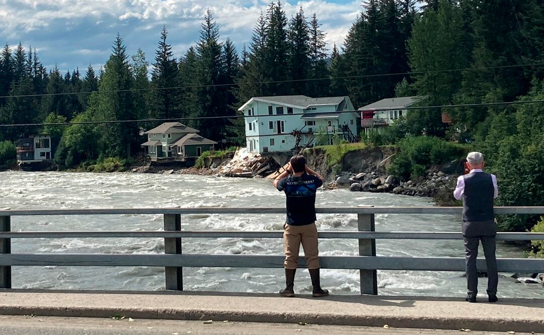 La gente se detiene en un puente sobre el río Mendenhall en Juneau, Alaska. Foto: AP
