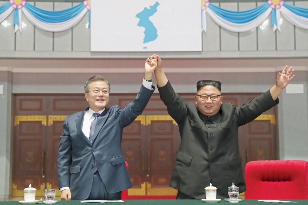 El presidente de Corea del Sur, Moon Jae-in, y el líder norcoreano, Kim Jong-un, levantan sus manos tras un evento deportivo en un estadio de Pyongyang. (AP)