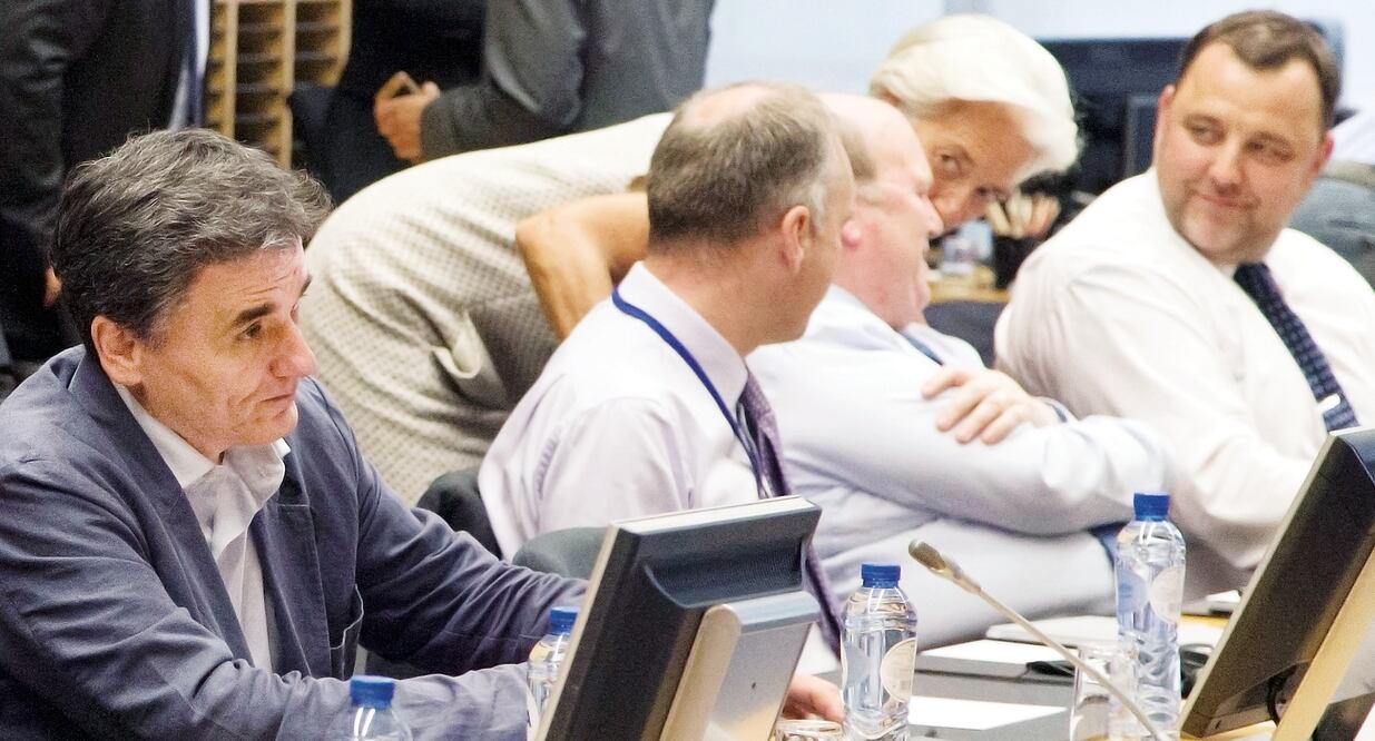 El ministro griego de Finanzas, Euclides Tsakalotos (izq.) espera el comienzo del encuentro de miembros de la eurozona en Bruselas. La directora del FMI, Christine Lagarde, habla con el ministro irlandés Michael Noonan.