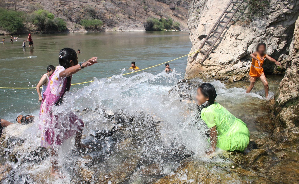 Niños jugando dentro de un río