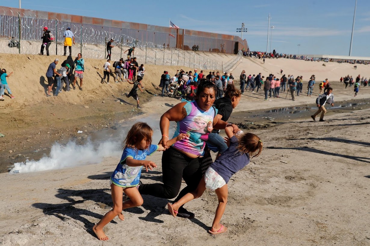 Migrante hondureña, aferrada a dos niñas pequeñas, huye de los gases lacrimógenos