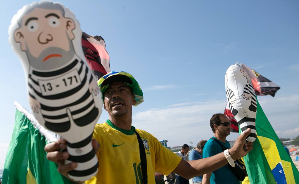 hombre con la bandera de Brasil y un muñeco que hace alusión al expresidente Lula da silva